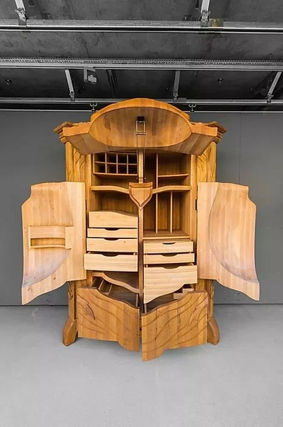 Придумал этот чудо-шкаф латвийский дизайнер Янис Страупе (JANIS STRAUPE . Более 35 лет он работает с деревом. Изготавливает скульптуры, декоративные предметы и мебель, которая больше похожа на