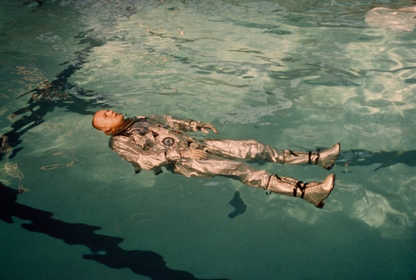 Облаченный в скафандр астронавт Нил Армстронг плавает в бассейне 